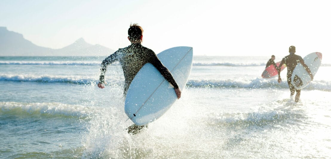 Surfer laufen ins Wasser
