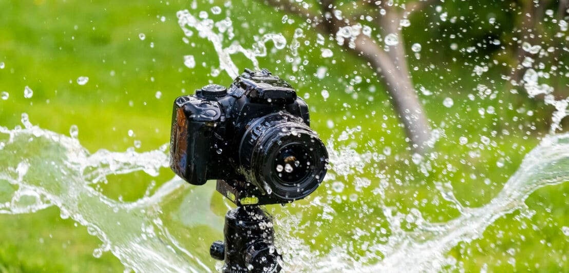Ein Fotoapparat wird nass gespritzt.
