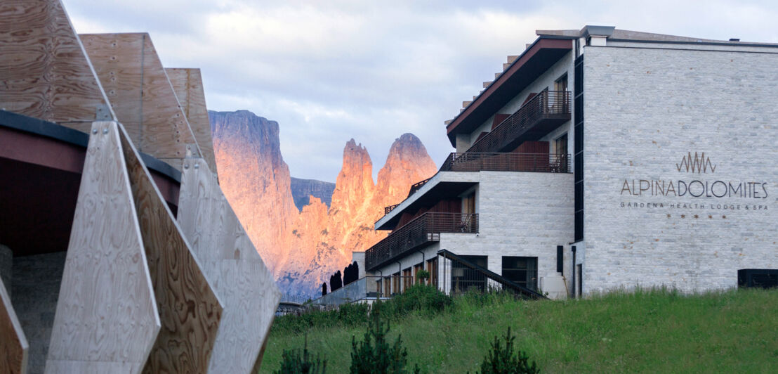 Hinter dem Hotel Alpina Dolomites werden die Gipfel der Dolomiten vom Licht des Sonnenuntergangs rötlich angestrahlt