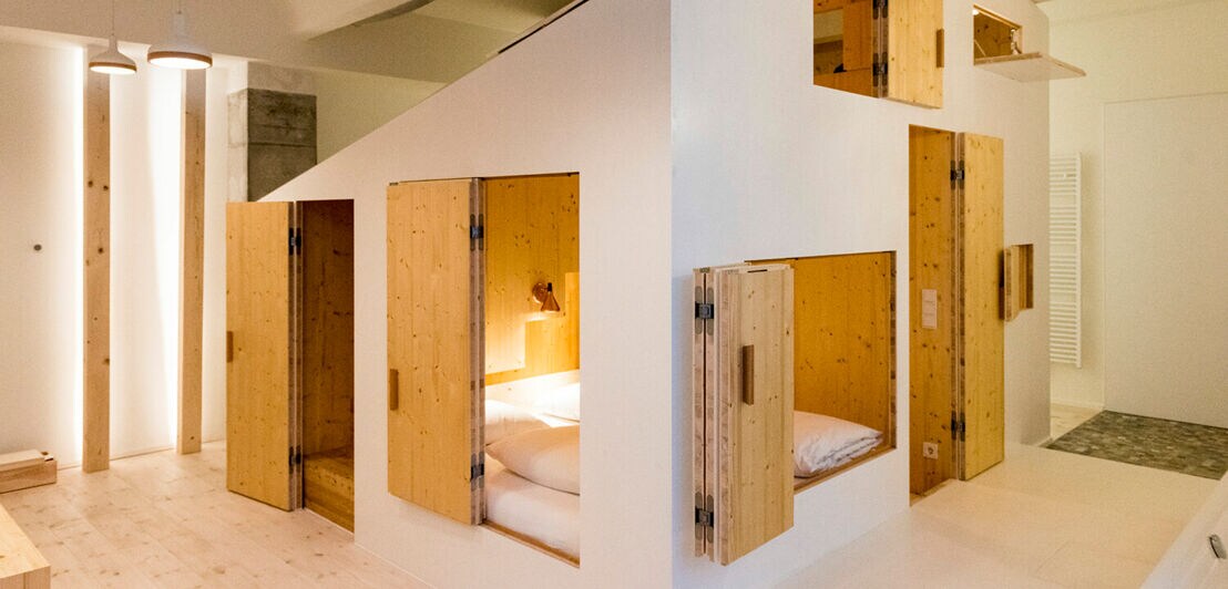 Ein kleines Schlafzimmer mit Türen und Fenstern in einem größeren Raum