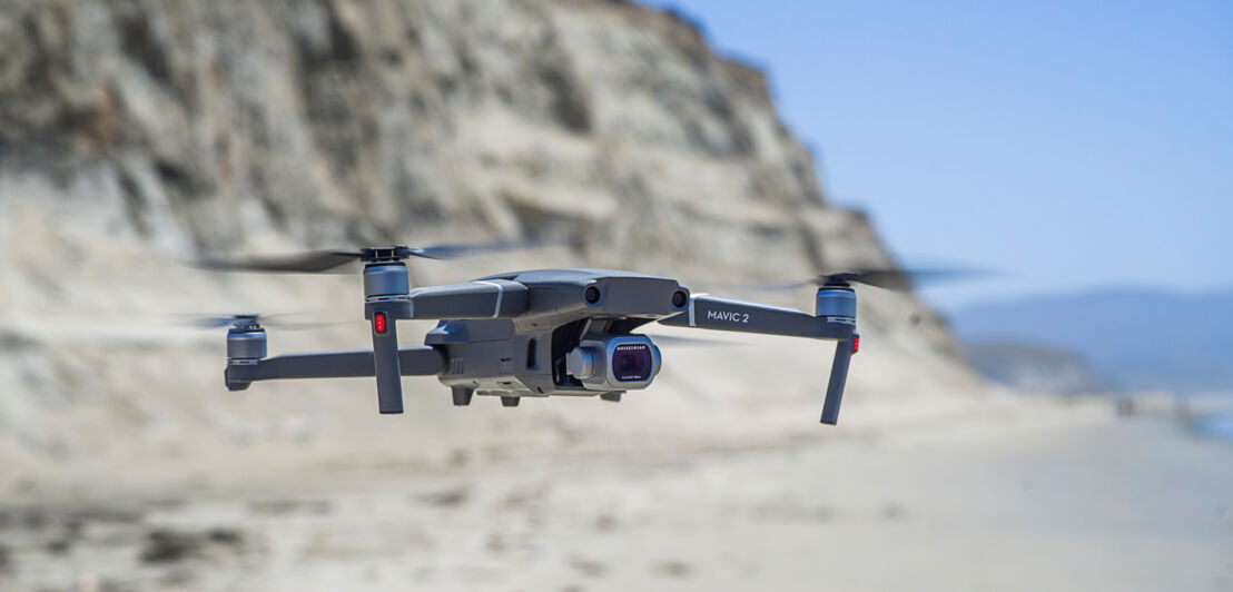 Eine Drohne des Herstellers DJI mit Hasselblad-Kamera fliegt an einem Strand