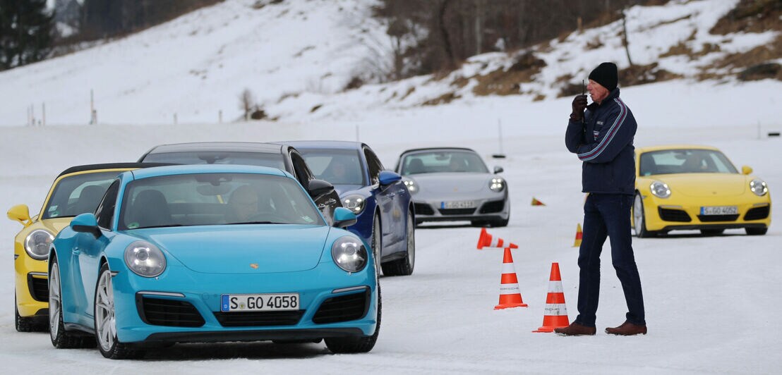 Mehrere Porsche fahren auf einer Teststrecke unter Anweisung der Rallyelegende Walter Röhrl