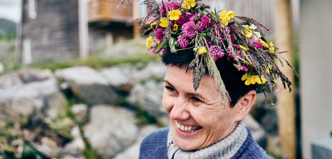 Ingunn Rasmussen lächelnd und mit Blumenkranz auf dem Kopf