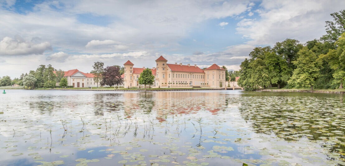 Schloss Rheinsberg spiegelt sich im Wasser.