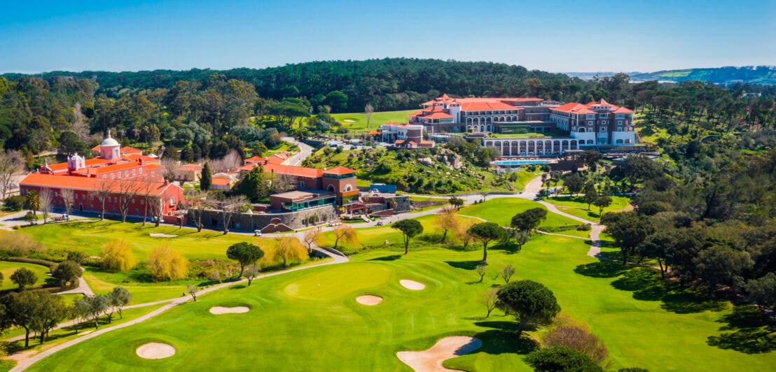 Eine große Hotelanlage und ein Golfplatz in hügeliger Landschaft