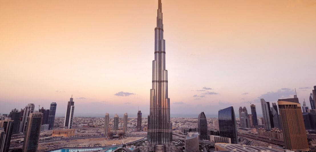 Die Skyline von Dubai im Abendlicht, in der Mitte das Gebäude Burj Khalifa
