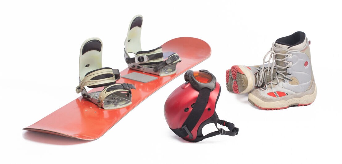 Ein Snowboard, ein Helm und Stiefel