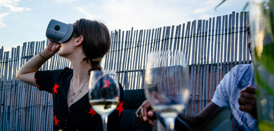 Frau mit VR-Brille bei der Weinverkostung.
