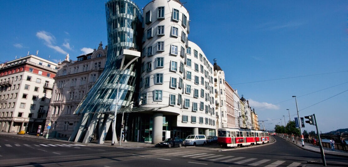 Zwei nebeneinanderstehende, organisch geformte Bürohäuser an einer Straßenkreuzung in Prag
