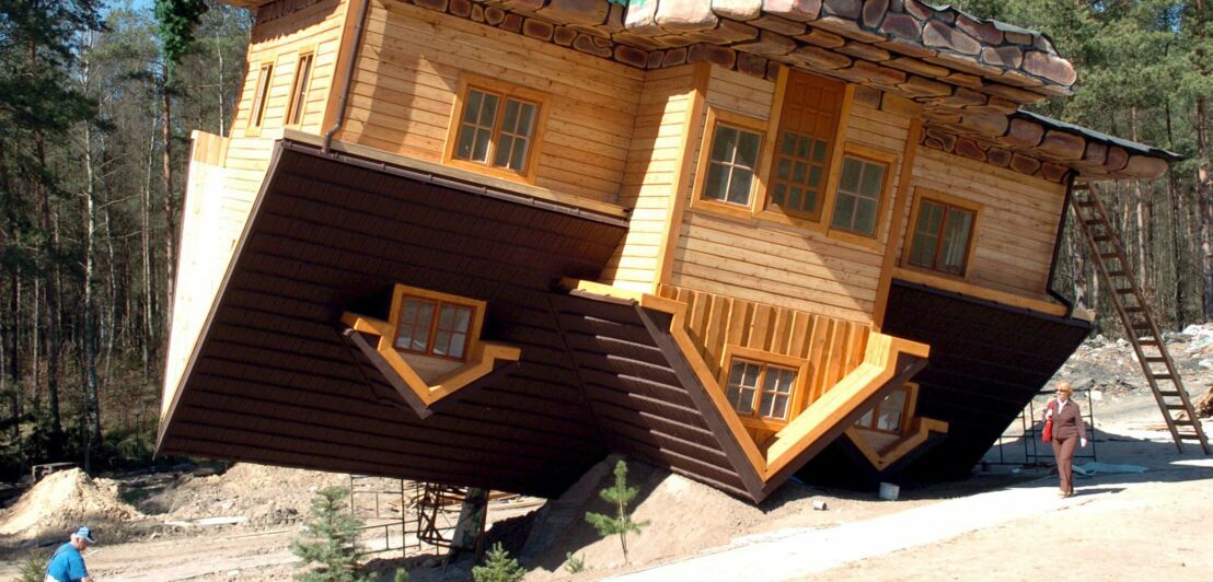 Ein installiertes Holzhaus als Kunstwerk, das auf dem Kopf steht