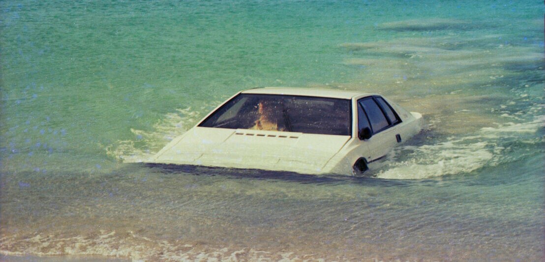 Ein weißer Lotus Esprit S1 fährt aus dem Wasser ans Land
