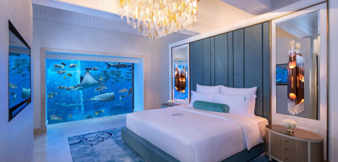 Eine luxuriöse Hotelsuite mit Panoramafenster zu einem Aquarium mit Fischen