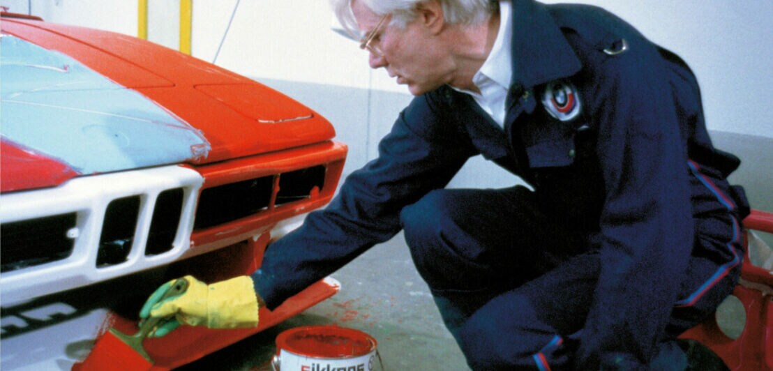 Andy Warhol bemalt ein Auto.