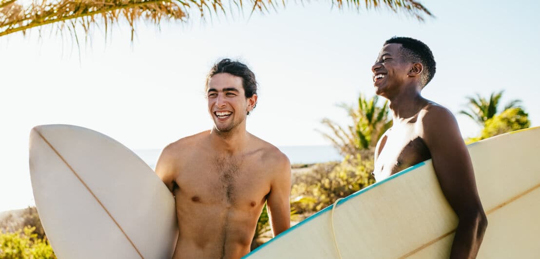 Zwei lachende Männer mit Surfbrettern