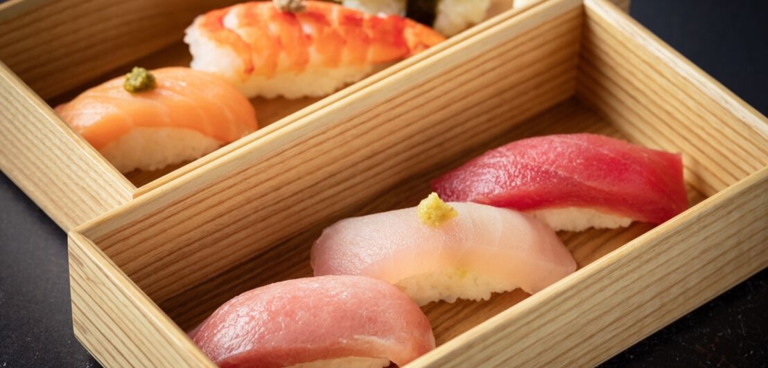 Nigiri Sushi in zwei Holzschalen.