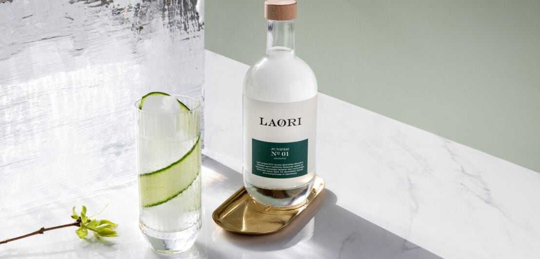 Flasche der Marke Laori neben einem Glas und Eisblock.