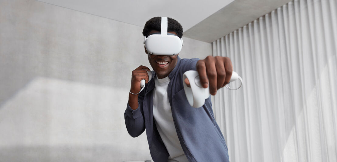 Ein Mann spielt mit der VR-Brille Oculus Quest 2 ein virtuelles Game.