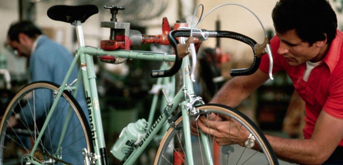 Ein Mann arbeitet an der Bremse eines Rennrads von Bianchi