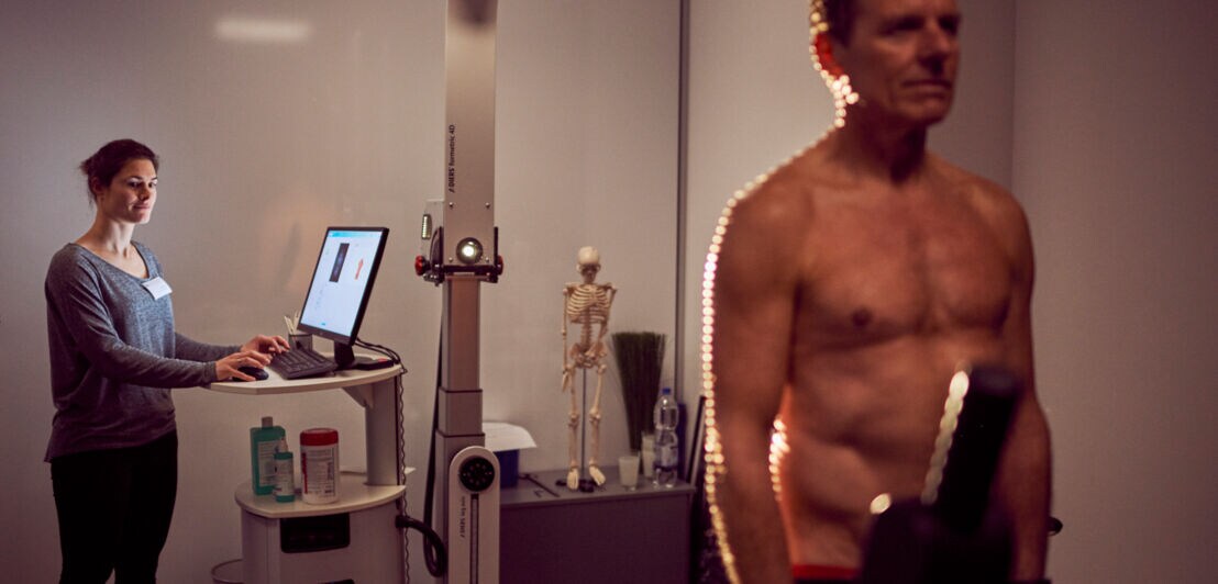 Der Körper eines Mannes wird mit einer technischen Einrichtung vermessen