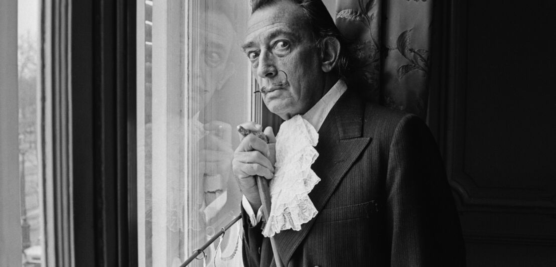 Schwarzweiß-Porträt des Künstlers Salvador Dalí an einem Fenster (1964)