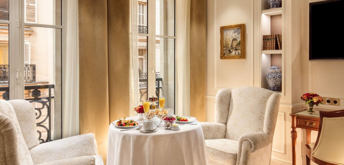 Gedeckter Tisch und zwei Sessel im Hotel Splendide Royal Paris.