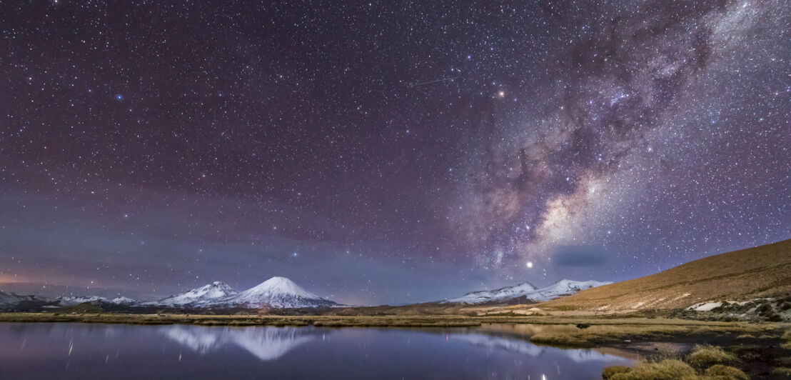 Die Milchstraße neben zwei Vulkanen in Chile.
