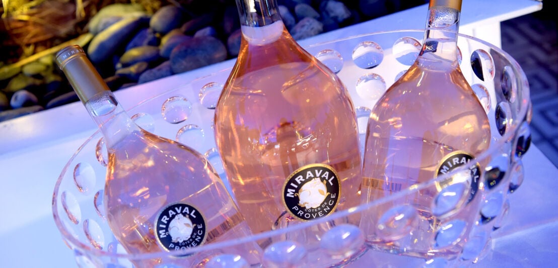Drei Flaschen Roséwein der Marke Miraval in einem Kühler
