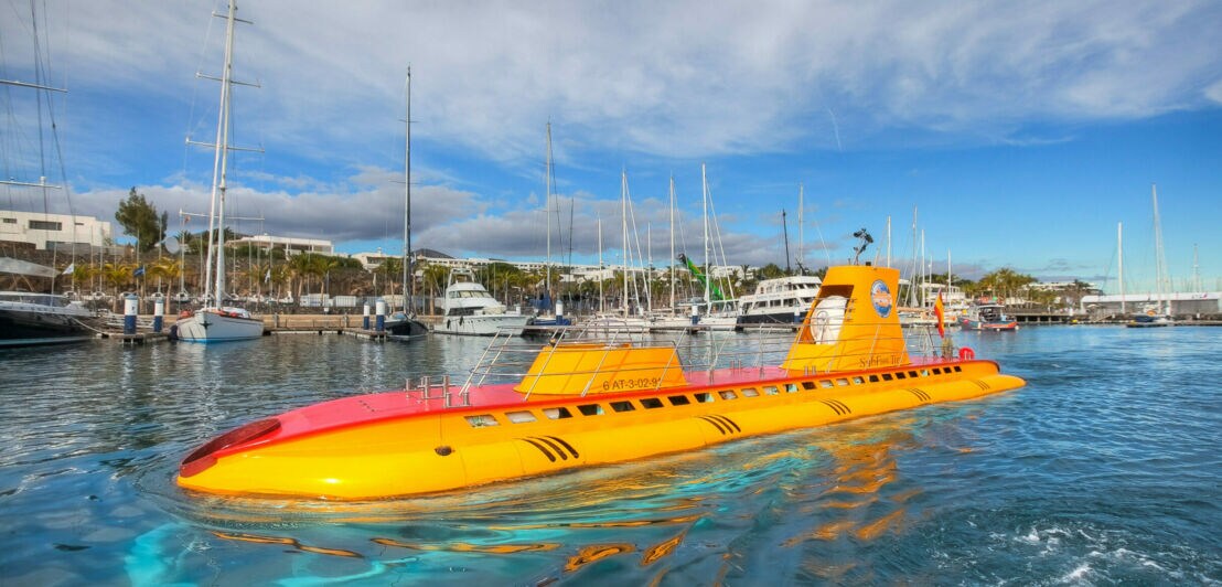 Orange-gelbes U-Boot des Anbieters Submarine Safaris an der Wasseroberfläche.