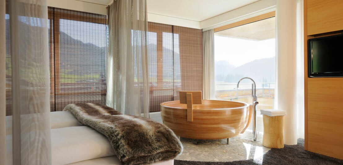 Eine moderne Hotelsuite mit runder Badewanne aus Holz