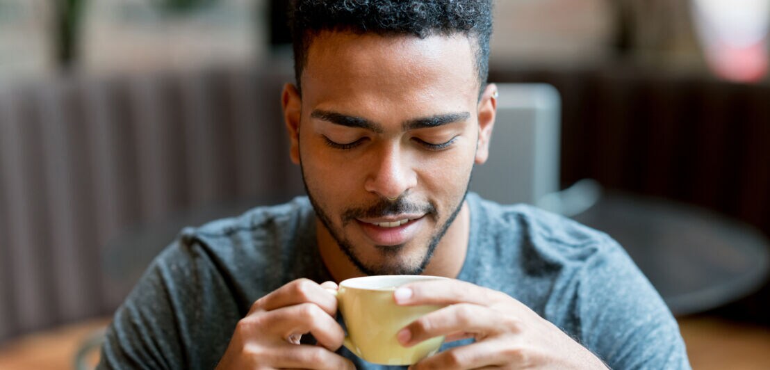 Ein Mann trinkt Kaffee aus einer Tasse.