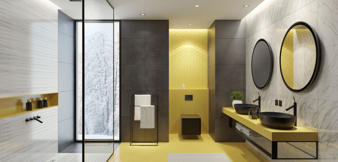Ein großes, modernes Badezimmer mit gelben Fliesen und schwarzen Details