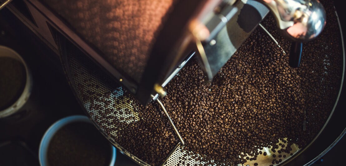 Der Prozess des Röstens einer Charge hochwertiger Kaffeebohnen in einem großen Industrieröster