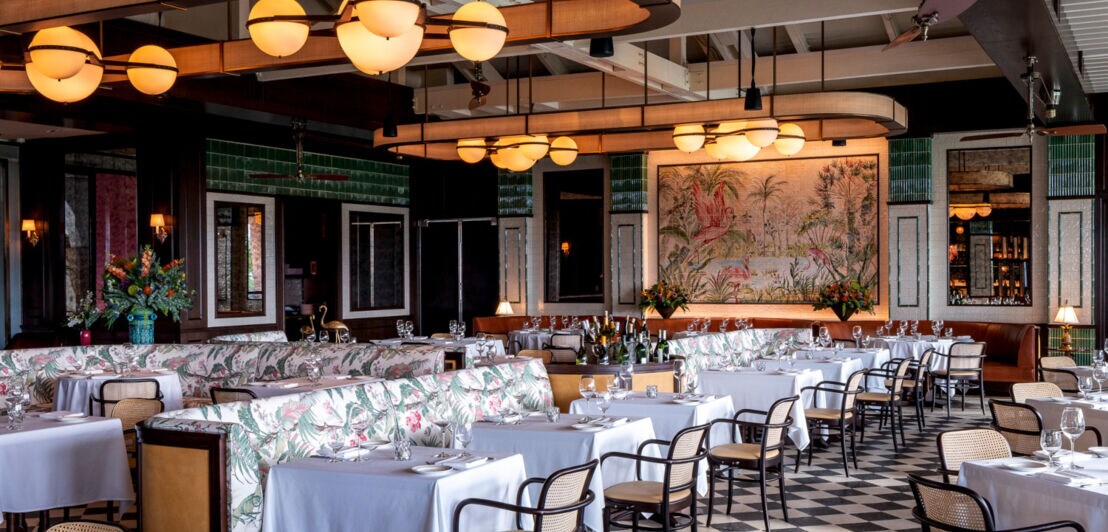 Blick in ein Restaurant, das floral und mit Flamingomotiven eingerichtet ist