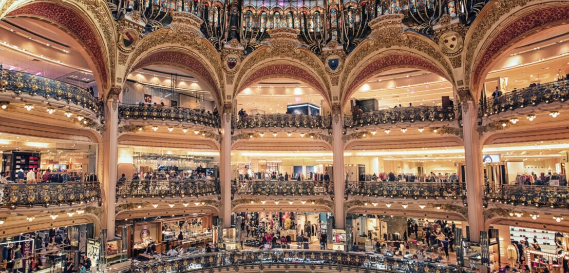 Zentrale, runde Halle des Pariser Kaufhauses Galeries Lafayette mit Balkonen und imposanter Glaskuppel in Jugendstilarchitektur