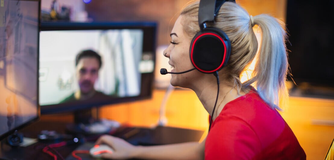 Eine junge Frau im roten T-Shirt spielt ein Online-Game