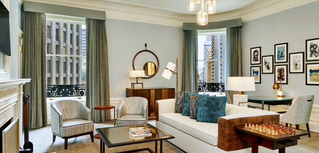Wohnzimmer einer noblen, stilvollen Hotelsuite mit bodentiefen Fenstern mit Stadtblick
