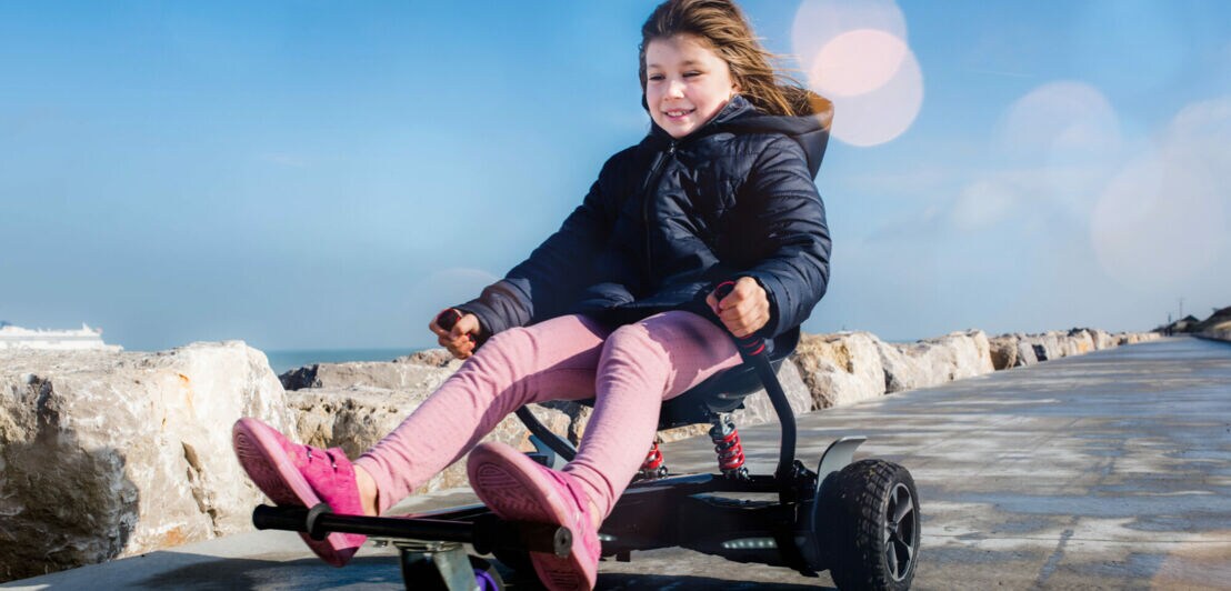 Ein kleines Mädchen fährt mit einem Hoverboard