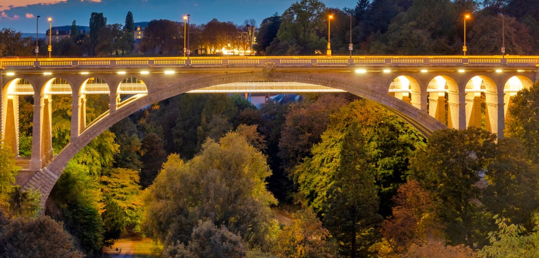 Blick auf die beleuchtete Adolphe-Brücke in Luxemburg in der Dämmerung.