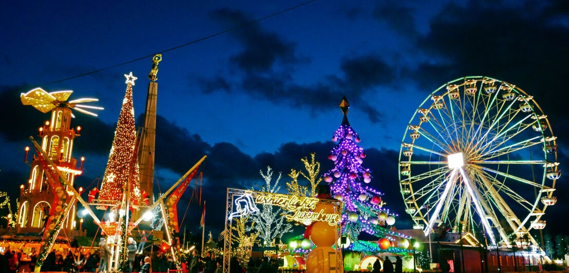 Bunt beleuchteter Weihnachtsmarkt mit Riesenrad in Luxemburg.