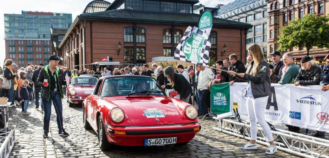 Ein roter Porsche am Start einer Rallye