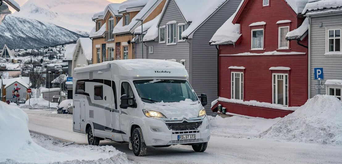 Ein Wohnmobil in den verschneiten Straßen von Tromsø