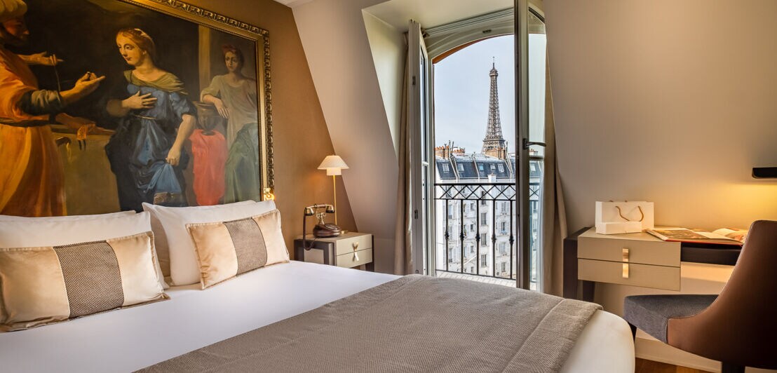 Ein Hotelzimmer mit offenem Fenster und dem Eiffelturm im Hintergrund