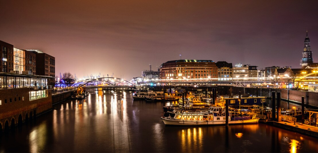 Der Hamburger Hafen bei Nacht mit Blick auf den beleuchteten Baumwall.