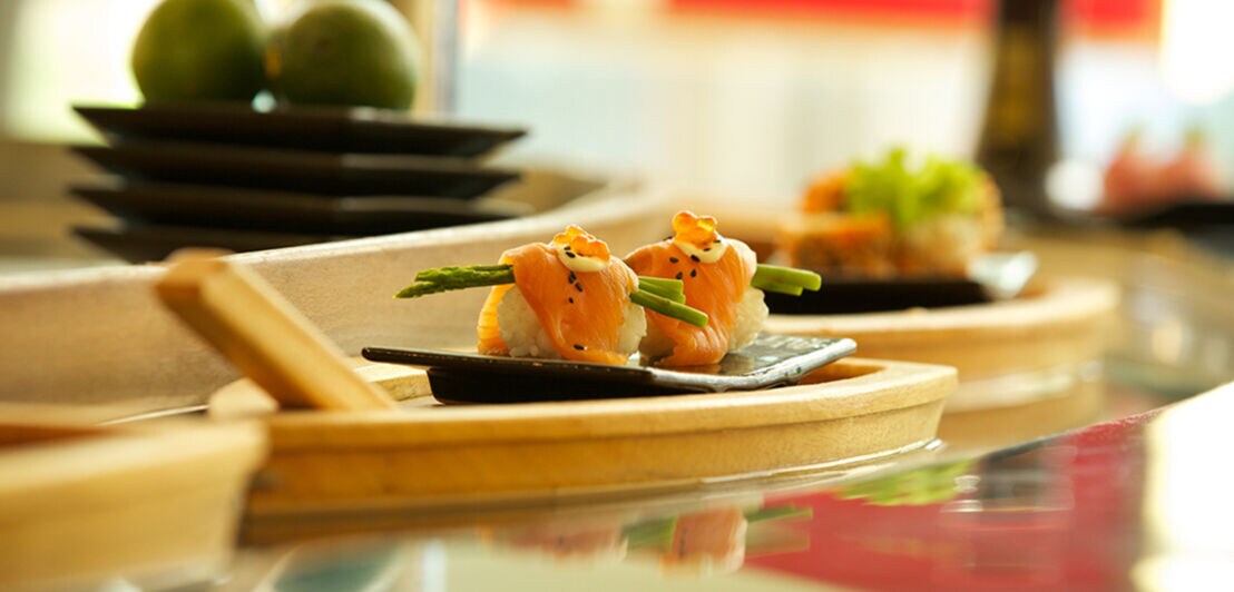 Sushi auf einem Teller in Schiffsform angerichtet.