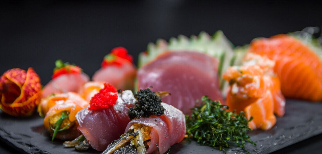 Sushi auf einer Schieferplatte angerichtet.