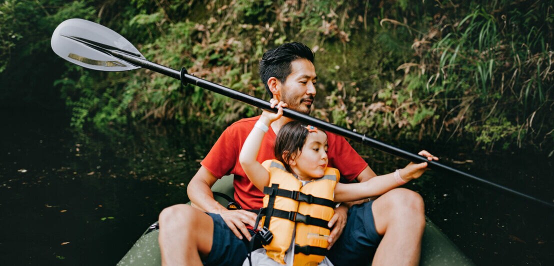 Ein Mann mit Tochter in einem Ruderboot