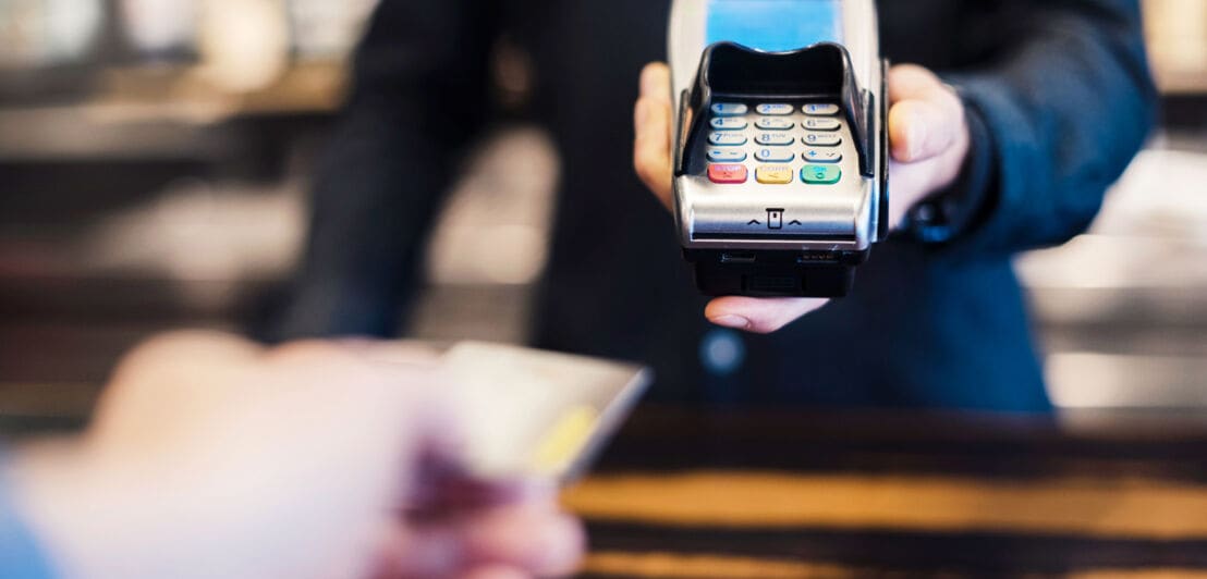 Eine Person zahlt mit Kreditkarte in einem Restaurant