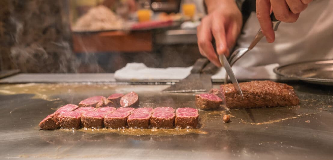 Ein Koch bereitet in einem Restaurant Kobe-Fleisch zu