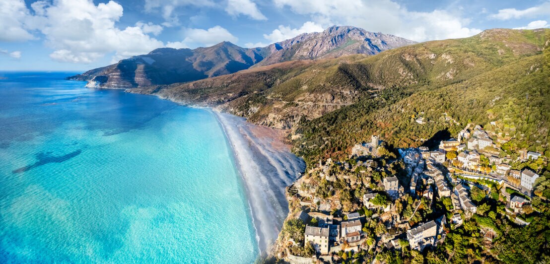 Luftaufnahme einer Meeresbucht mit bergiger Landschaft und türkisfarbenem Meer