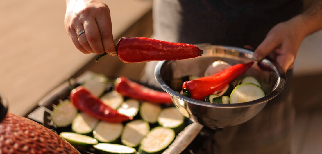Rote Spitzpaprika und Zucchini in einer Schale, die gleich in einen Grill gegeben werden